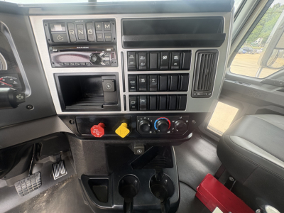 Dashboard of 2020 Mack GR64F showing steering column, gear selector, multiple switches, warning lights, and control knobs.