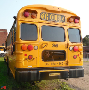 Rear view of a yellow 2018 Blue Bird Vision school bus showing the back doors, tail light clusters, and a 'SCHOOL BUS' plate.