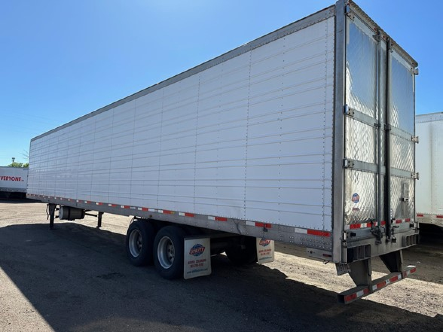 Trailer side view of a 2013 Utility 3000R storage trailer showing tandem rear wheels and closed silvery walls.