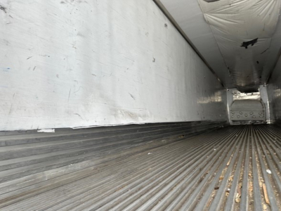 Interior of a 2013 Utility 3000R trailer cargo area showing ribbed aluminum floor and sidewall with some wear.