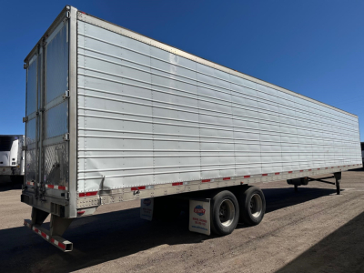 Trailer side view of a 2013 Utility 3000R storage trailer showing tandem rear wheels and aluminum exterior.