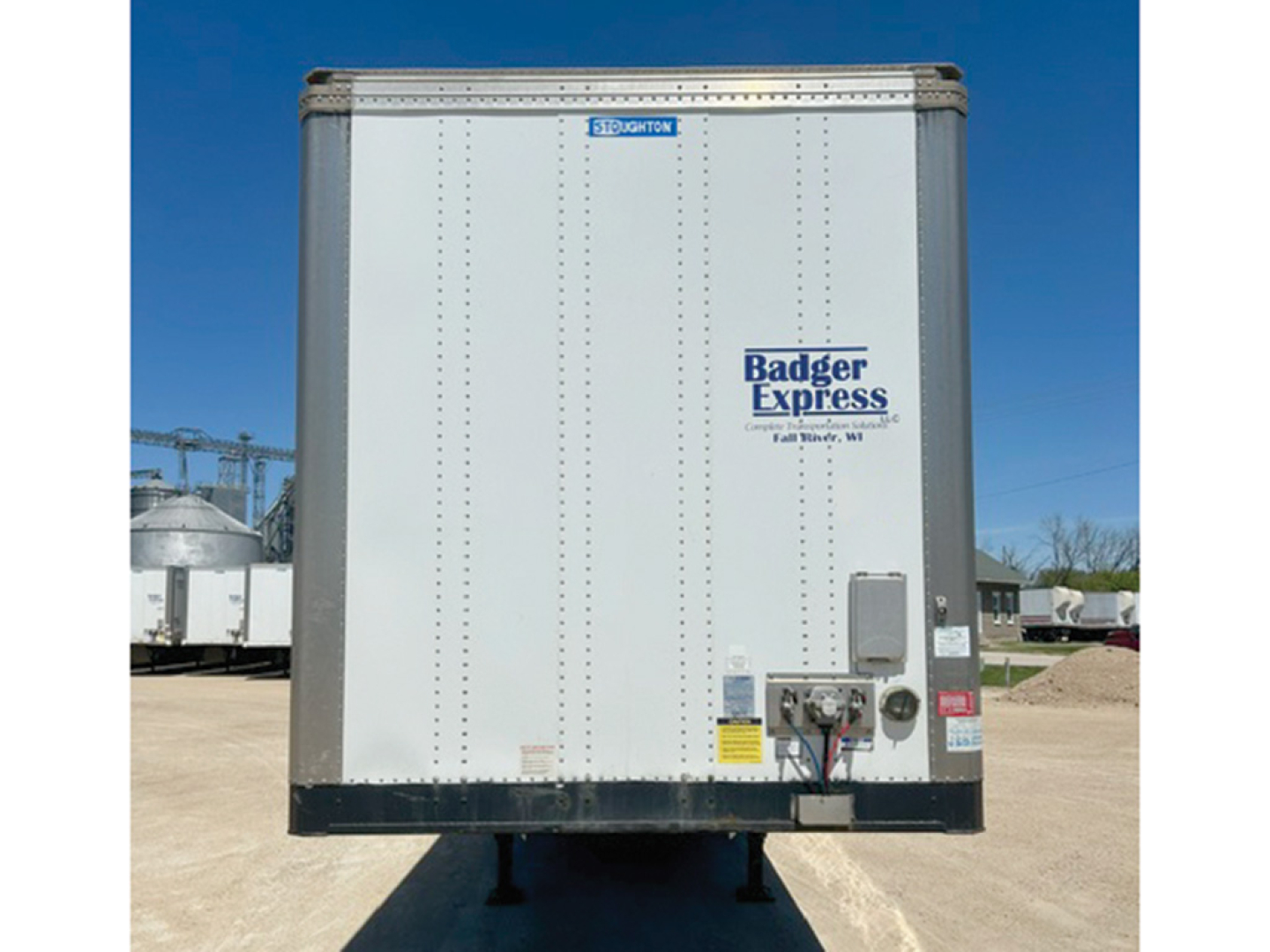 Stoughton trailer front view showing Badger Express logo and control panel with safety labels.