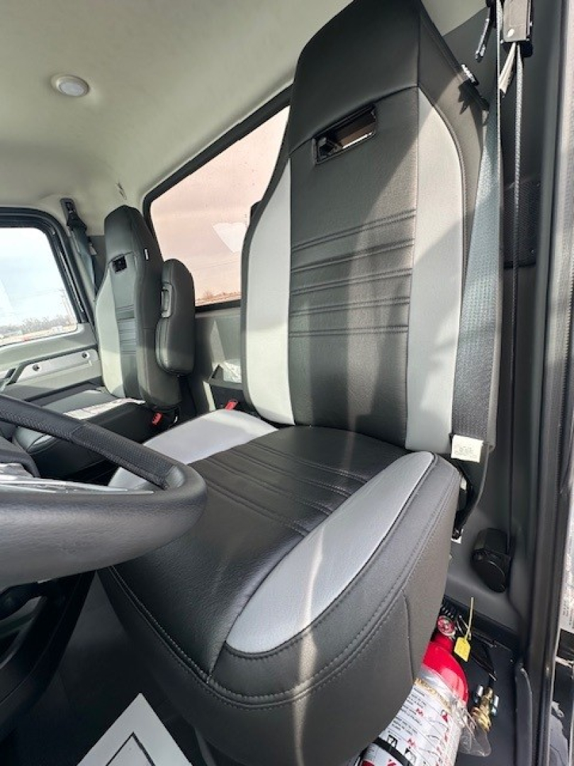 Cab interior of a 2025 Mack GR104F dump truck showing driver's seat and passenger seat with black and gray upholstery.
