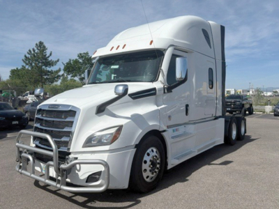 Freightliner Cascadia 126 cab-over sleeper tractor in white, front grille with bull bar, side mirrors, and aerodynamic fairing visible.