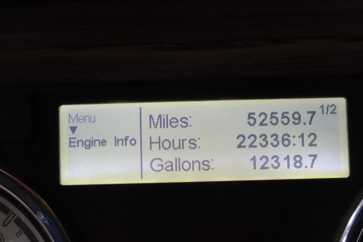 Dashboard display showing Miles/Hours/Gallons readings on a Freightliner SD122 cab truck.