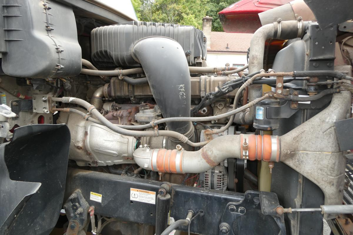Freightliner SD122 engine bay showing turbocharger, intercooler piping, hoses, and radiator area.