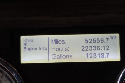 Dashboard display showing Miles/Hours/Gallons readings on a Freightliner SD122 cab truck.