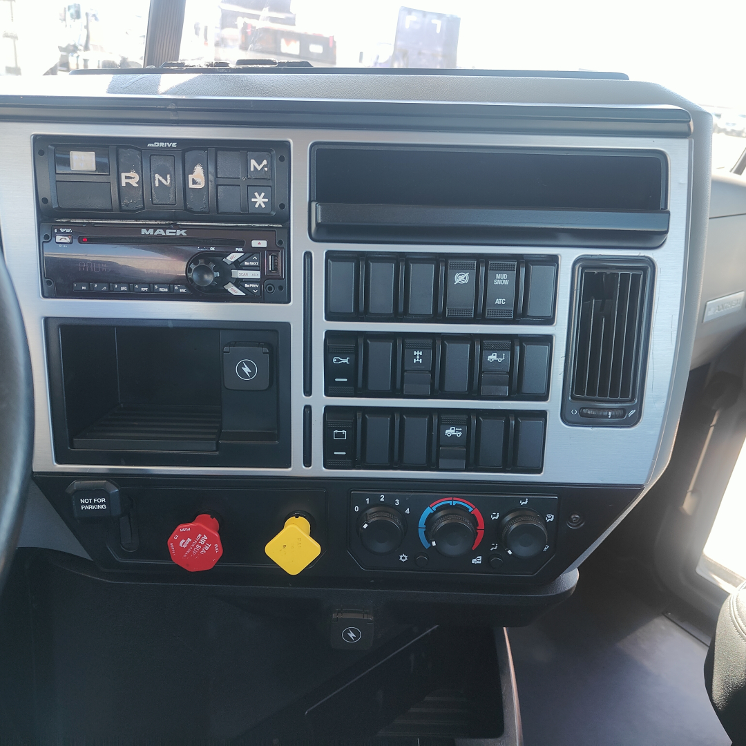 Dashboard of a 2019 Mack Anthem truck showing steering column, climate controls, switch panel, and gear shifter indicators.