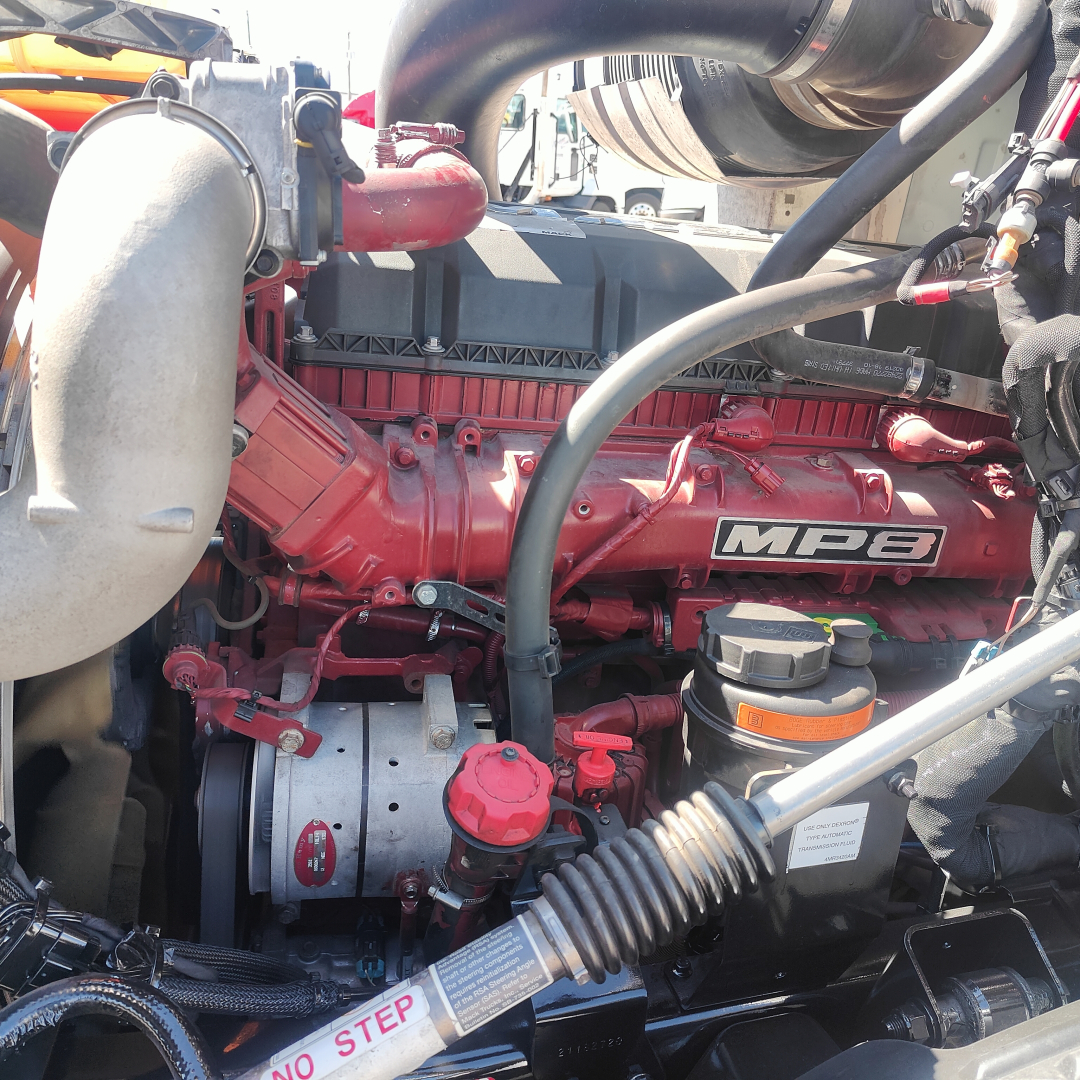 Engine bay of a 2019 Mack Anthem showing a red MP8 engine with surrounding hoses and components.