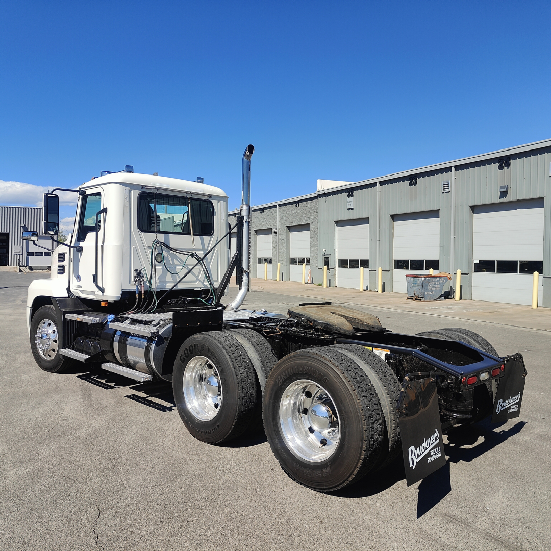 2019 Mack ANTHEM conventional daycab tractor chassis and rear view showing dual rear axles and fifth wheel, white cab, blue skies