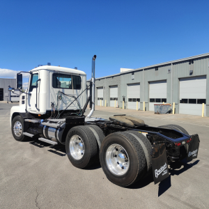 2019 Mack ANTHEM conventional daycab tractor chassis and rear view showing dual rear axles and fifth wheel, white cab, blue skies
