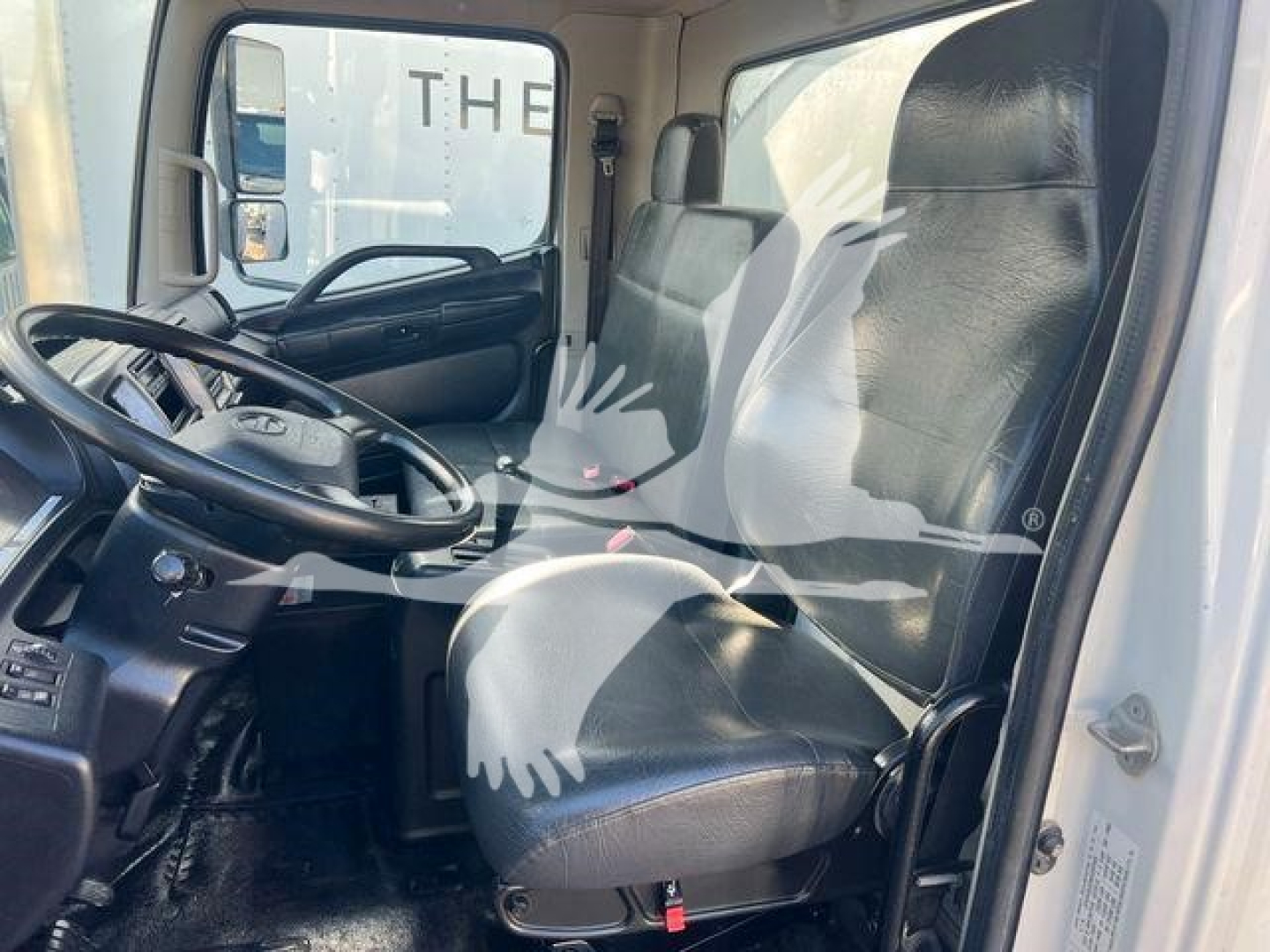 Cab interior of a 2019 Hino 338 truck showing steering wheel and driver's seat.