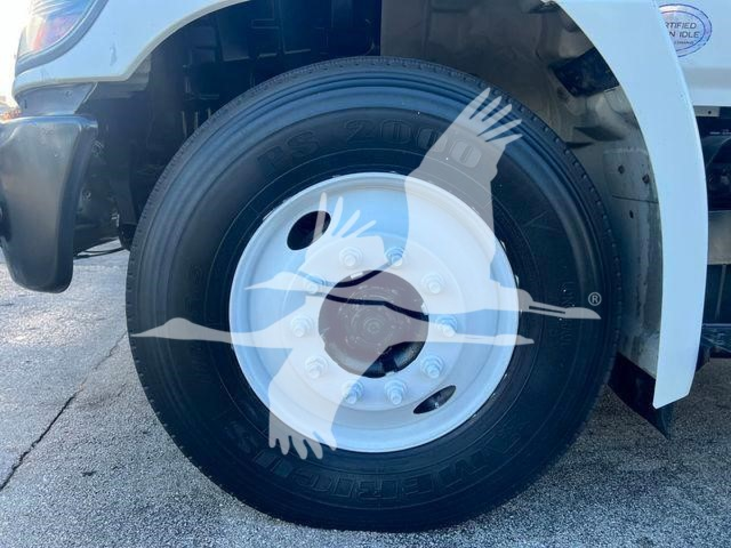 Wheel and tire of a 2019 Hino 338 front axle showing steel wheel with hub and tire sidewall details.