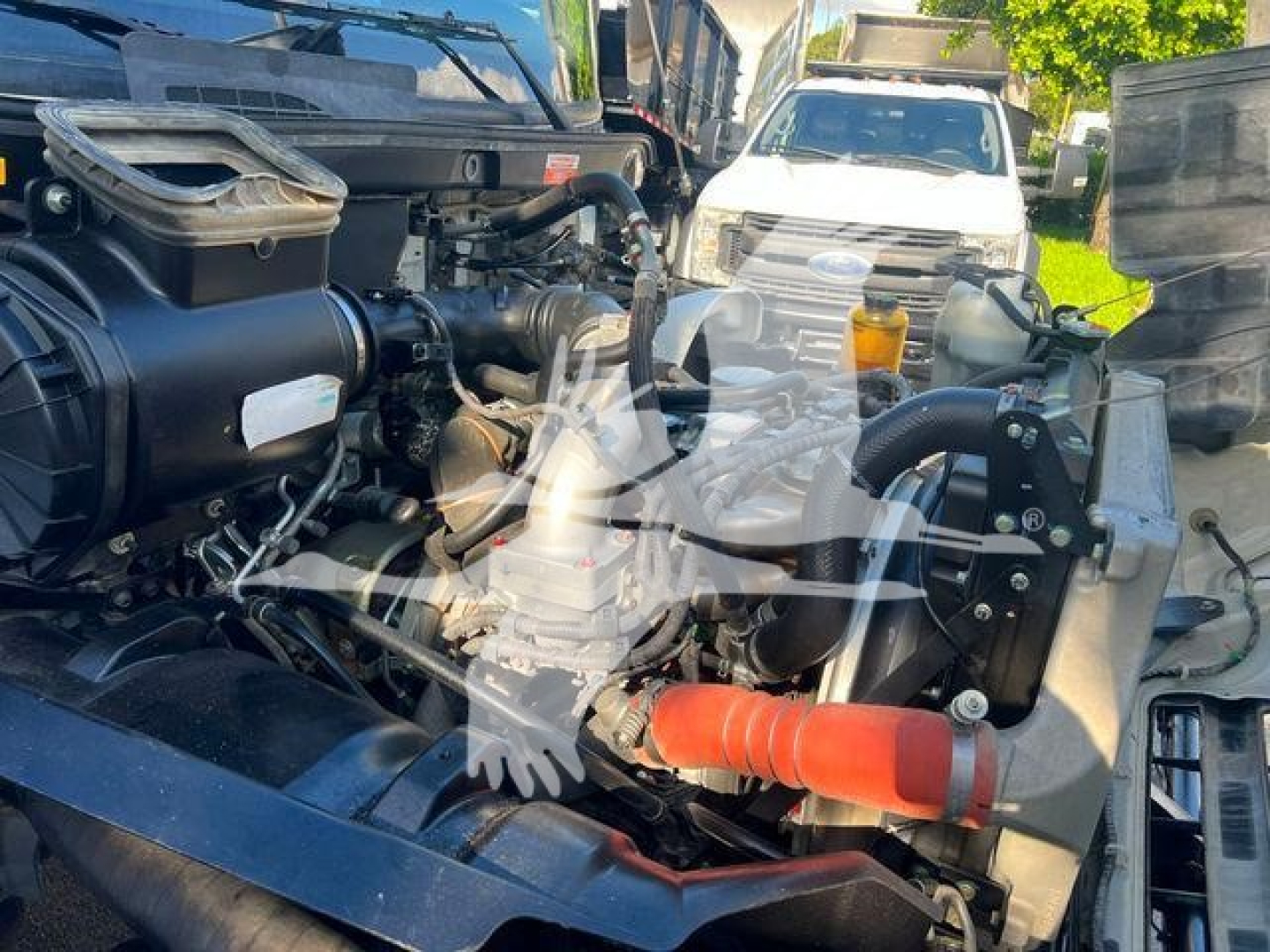 Hino 338 engine bay showing air intake, coolant reservoir, hoses, and engine components.