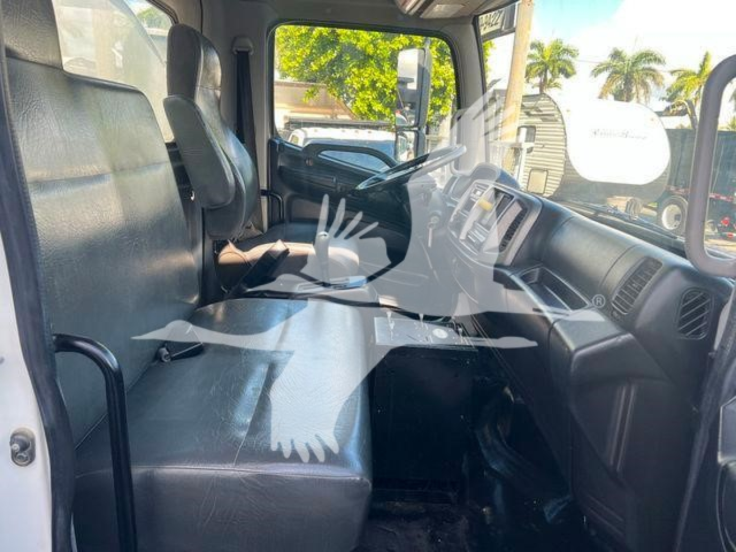 Interior of a 2019 Hino 338 cab showing front bench seat, steering wheel, and dashboard area.