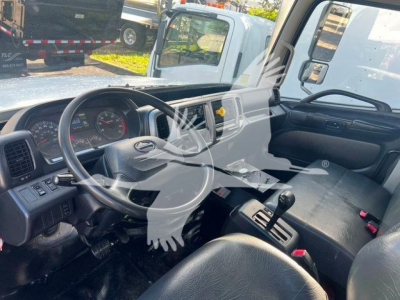 Cab interior of a 2019 Hino 338 toward the driver's seat with steering wheel, dashboard, and gear shifter visible.