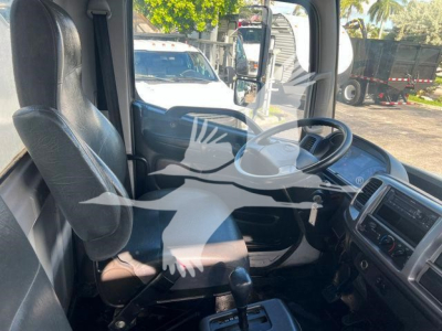 Truck cab interior of a 2019 Hino 338 showing driver's seat, steering wheel, dashboard, and gear shifter.