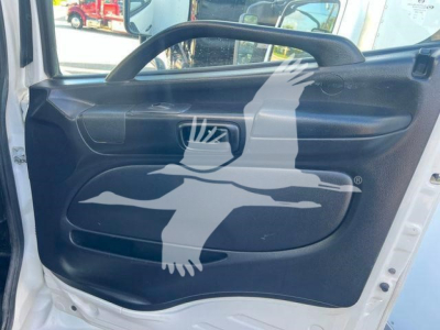 Vehicle interior door panel of a 2019 Hino 338 showing black door trim with handle and window control area.