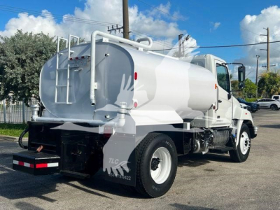 Truck rear with cylindrical tank, rear ladder, and hoses. Visible text includes TLC on mudflap and some numbers on plate area; no clear legible brand text besides stock features.