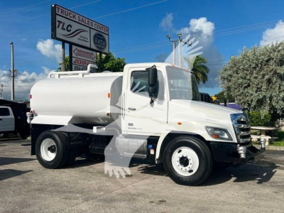 2019 Hino 338 fuel tanker truck in showroom pose showing white cab and cylindrical tank with dual rear wheels.
