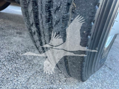 Tire and fender of a 2019 Hino 338 truck showing tread detail and wheel well.