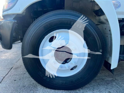 Wheel and tire of a 2019 Hino 338 front axle showing steel wheel with hub and tire sidewall details.
