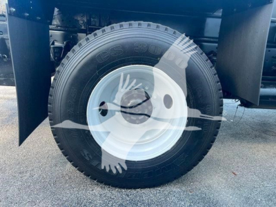 Truck wheel with US 20 cement printed tire and white steel rim, part of a Hino 338 chassis, showing tire and wheel assembly.