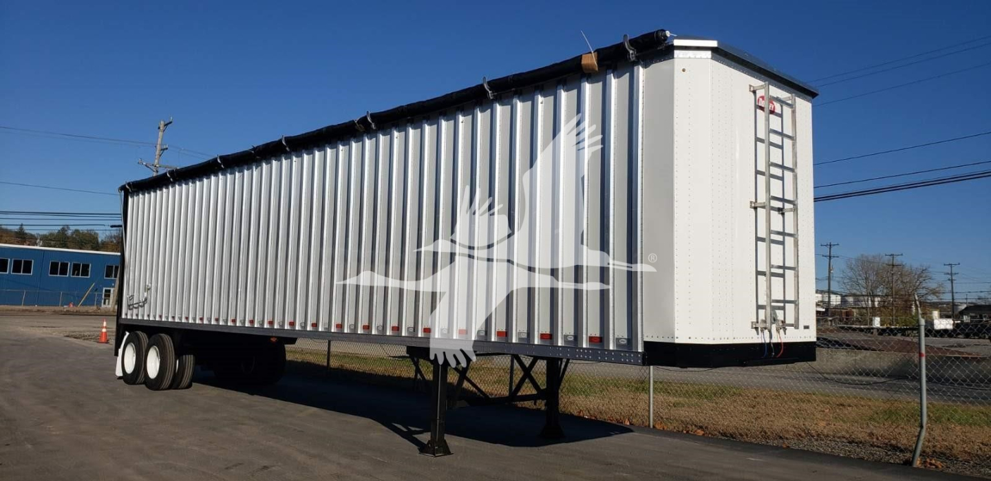 Open top trailer by Dorsey showing white bird silhouette graphic on silver corrugated side and rear ladder.