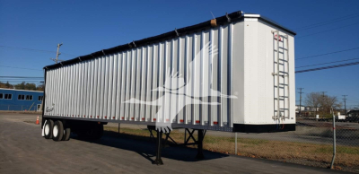 Open top trailer by Dorsey showing white bird silhouette graphic on silver corrugated side and rear ladder.