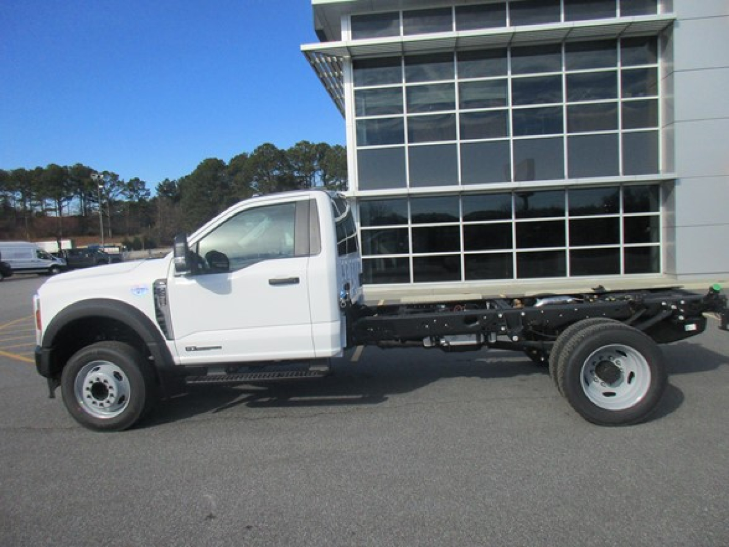 Ford F-450 cab and chassis side view with white cab, black chassis, and dual rear wheels.