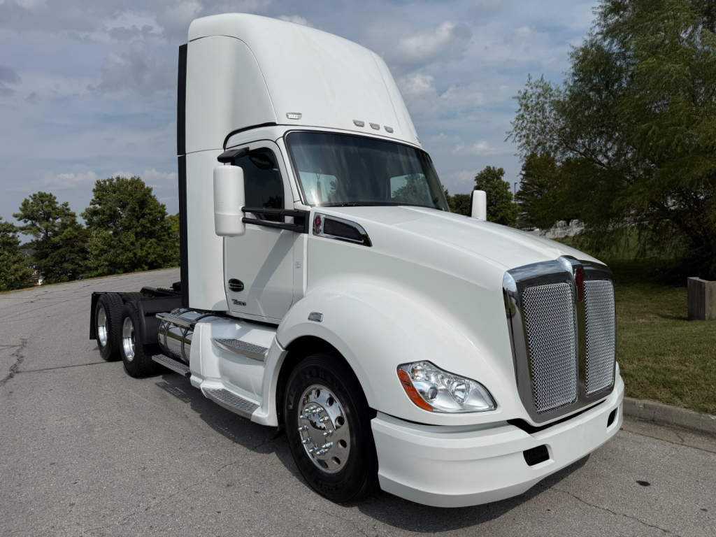 Kenworth T680 daycab tractor showing side view with white exterior and chrome grille.