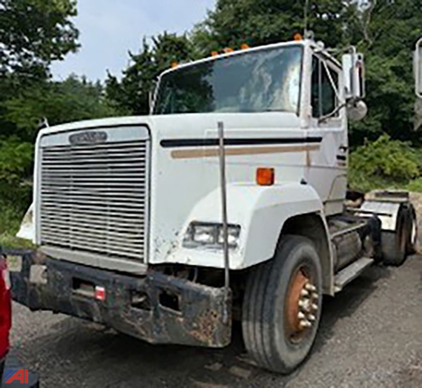 Freightliner FLC112 tractor truck front-left view with plow mount, white cab, large grille, in-service condition