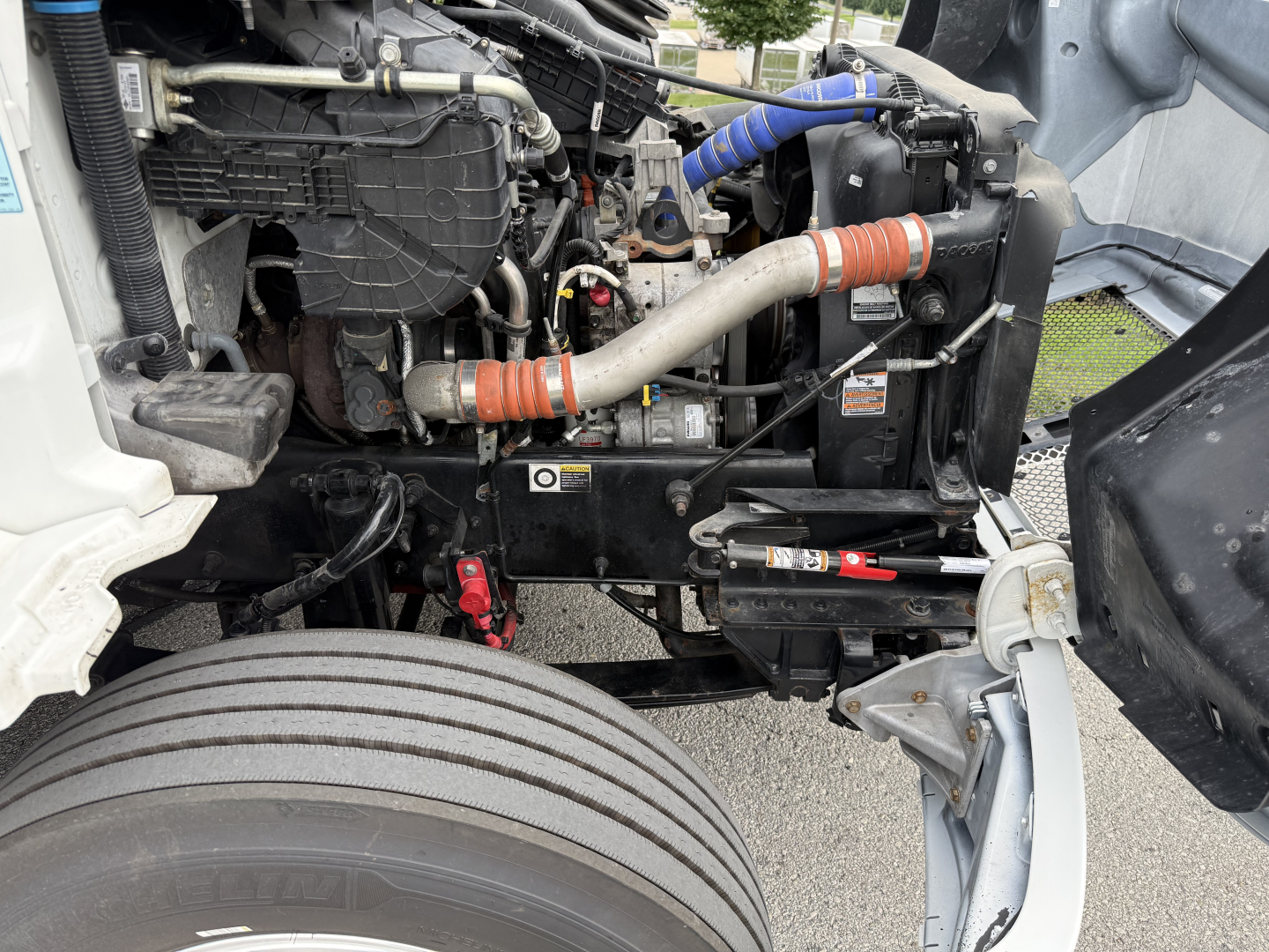 Kenworth T380 engine bay showing coolant hoses, radiator, and suspension components.