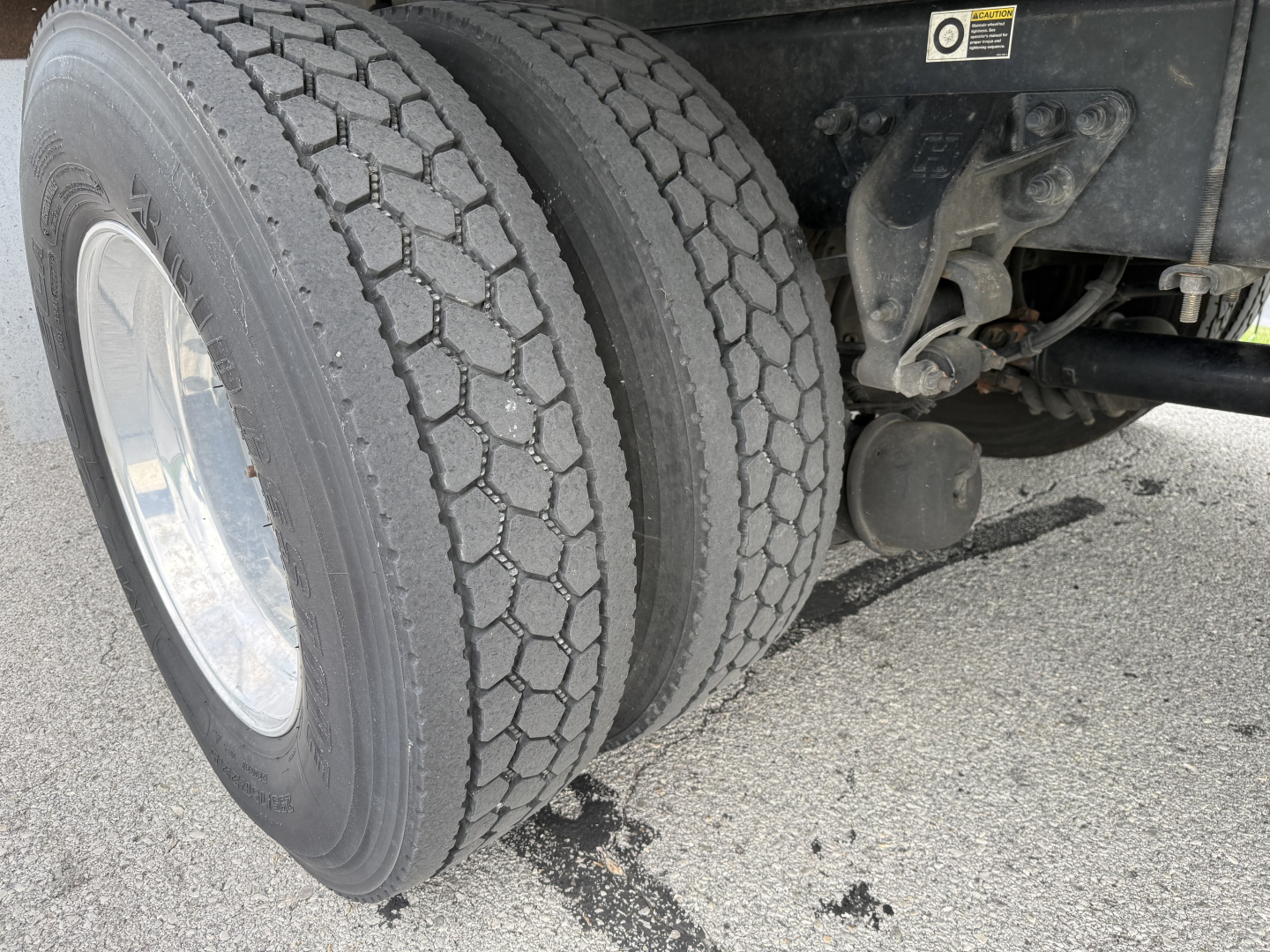 Kenworth T380 rear dual tires and suspension undercarriage view showing trailer hitch and air lines.