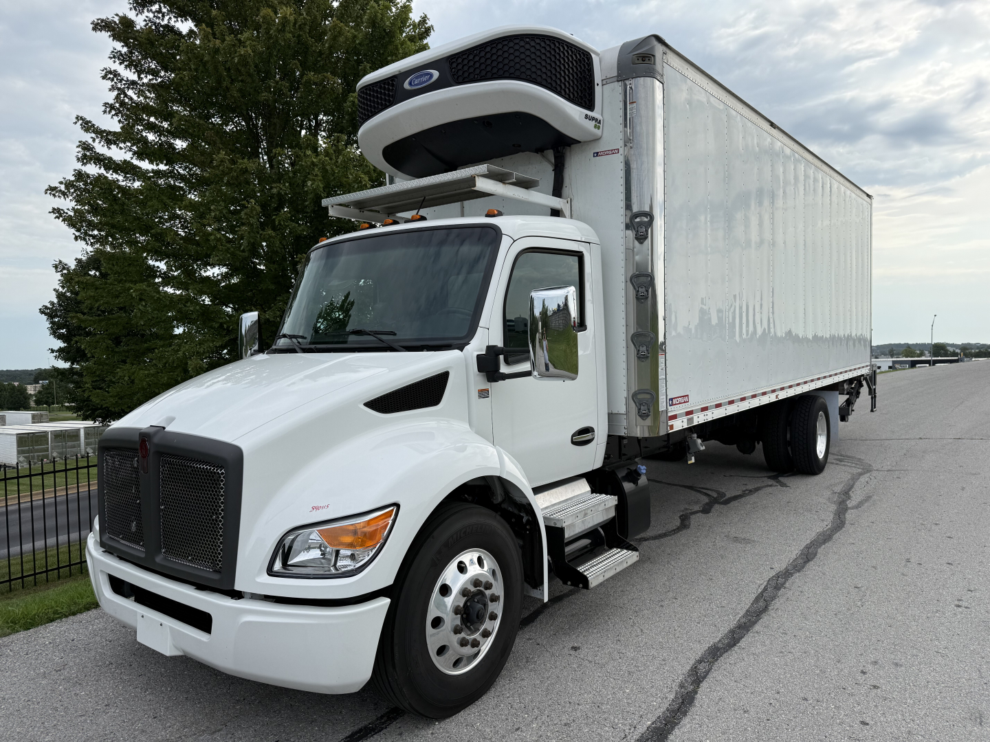 Truck in service showing a Kenworth T380 refrigerated box with a rooftop refrigeration unit and white cab. VIN 2NK4HM7X2PM266510, stock 0627323.