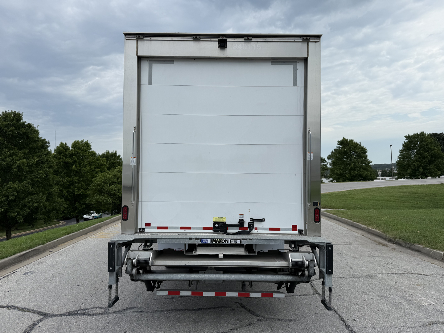 Rear view of a 2023 Kenworth T380 refrigerated truck with roll-up rear doors and a liftgate, stock number 0627323.VIN 2NK4HM7X2PM266510 is visible in listing.