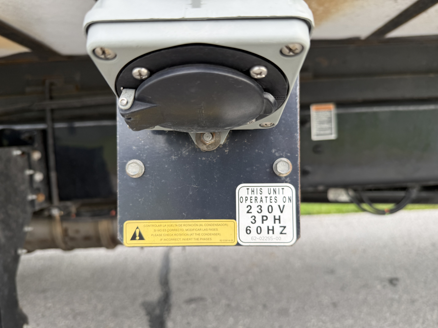 Kenworth T380 refrigeration unit hitch with circular power connector and two warning labels, showing a 230V 60Hz operating plate.
