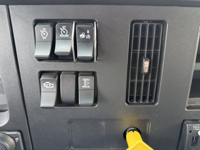 Kenworth T380 cabin dashboard controls and air vent with a yellow power plug visible