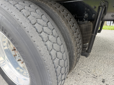 Kenworth truck dual rear tires and undercarriage view in serviceable condition with suspension components visible.