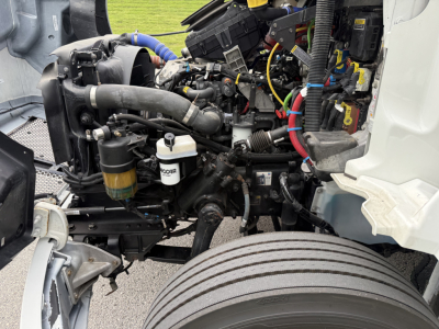 Kenworth T380 engine bay with visible components including coolant reservoir, hoses, wiring, and refrigerated truck drivetrain.