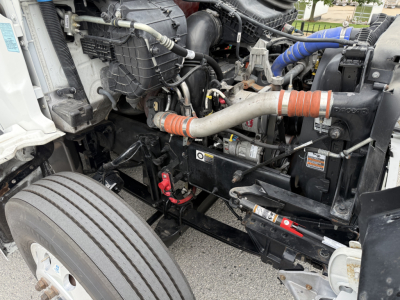 Kenworth T380 engine bay showing coolant hoses, air intake, and wiring with label stickers visible.