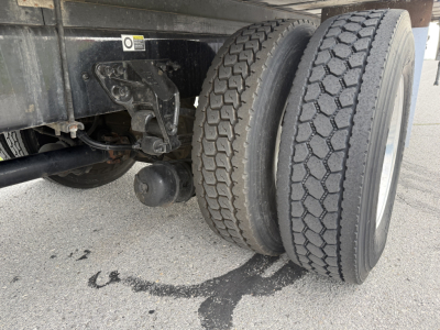 Kenworth T380 rear dual tires and chassis showing wheel area and undercarriage, with oil/fluid trace on pavement.