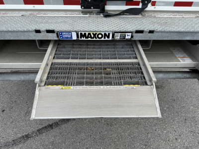 Truck rear showing a cargo lift/step with MAXON label and rear bumper, generic Maxon gate.