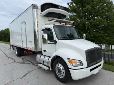 Kenworth T380 refrigerated truck with a side door box and front grille visible, mounted refrigeration unit on top, white cab and trailer.
