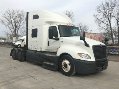 Truck cab and chassis of a white 2023 International LT625 sleeper with several wheels visible and VIN tag not legible.