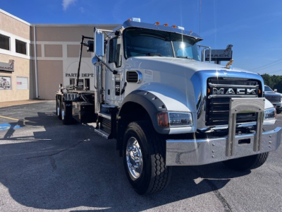 White Mack GR64F truck in a dealership lot with chrome bumper and grille, side view showing cab and bed.
