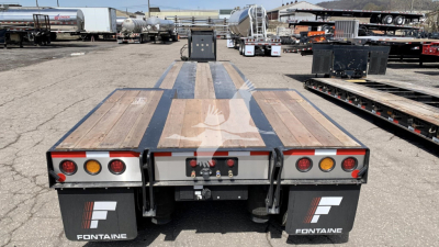  Fontaine N12 lowboy trailer rear view showing taillights and mud flaps with Fontaine logos.