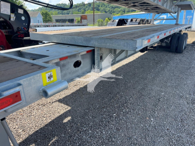 Flatbed trailer deck with Dorsey branding and VIN sticker; side rails, reflectors, and wheel axle visible undercarriage; tag shows 2027 Dorsey Extendable trailer.