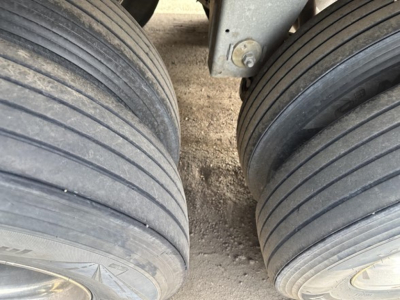 Trailer axle tires and suspension view showing dual tires on Stoughton air ride grain trailer (grain trailer hitch area visible).