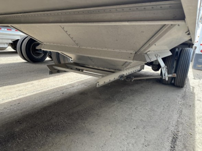 Stoughton air ride grain trailer underside showing suspension and hopper bottom with beam brackets and mounting hardware.